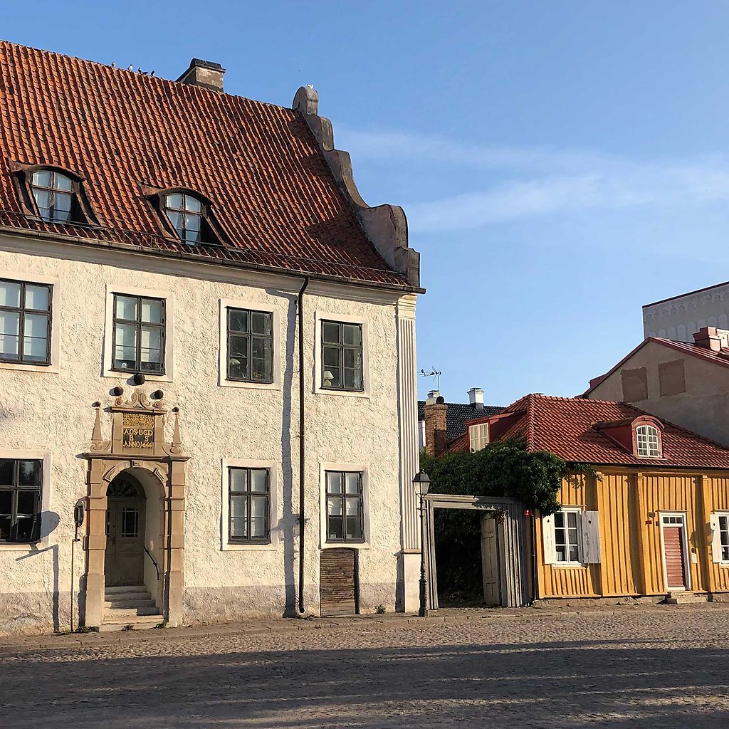Vitt stenhus och mindre gult trähus på Lilla Torget.