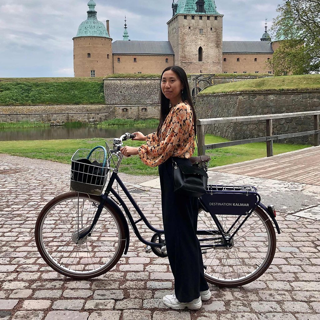 Thuha Nguyen står med en cykel framför Kalmar Slott